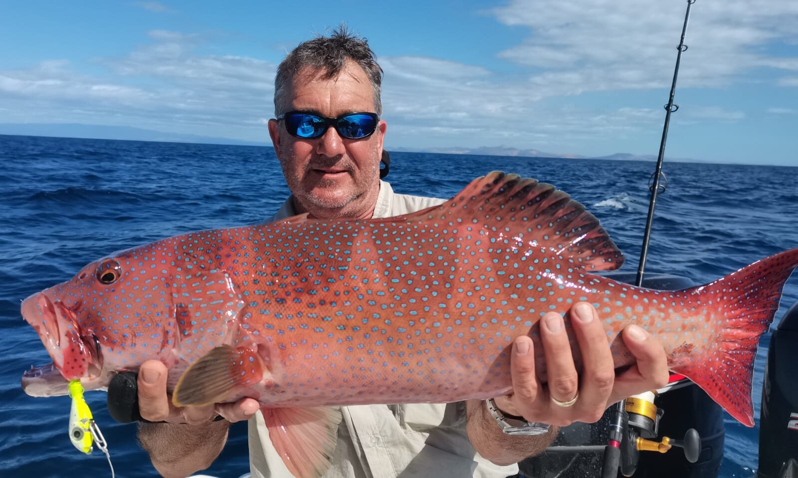 An angler holding a coral trout off Nosy Be