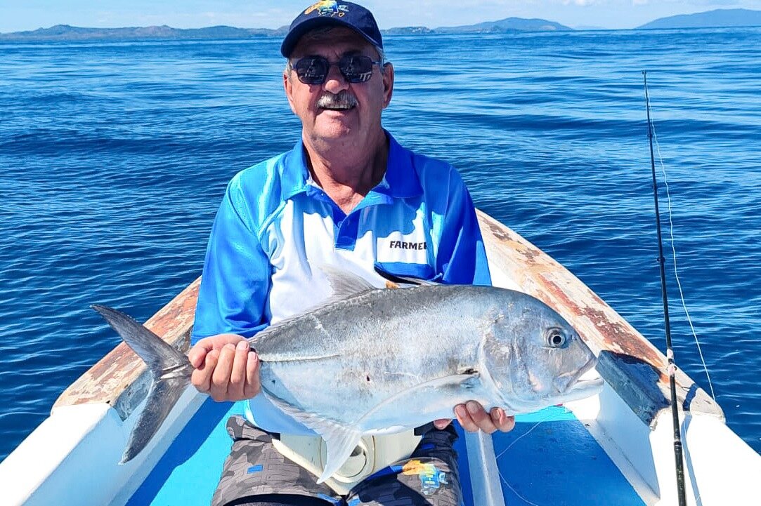An angler with a giant trevally in the boat off Nosy Be