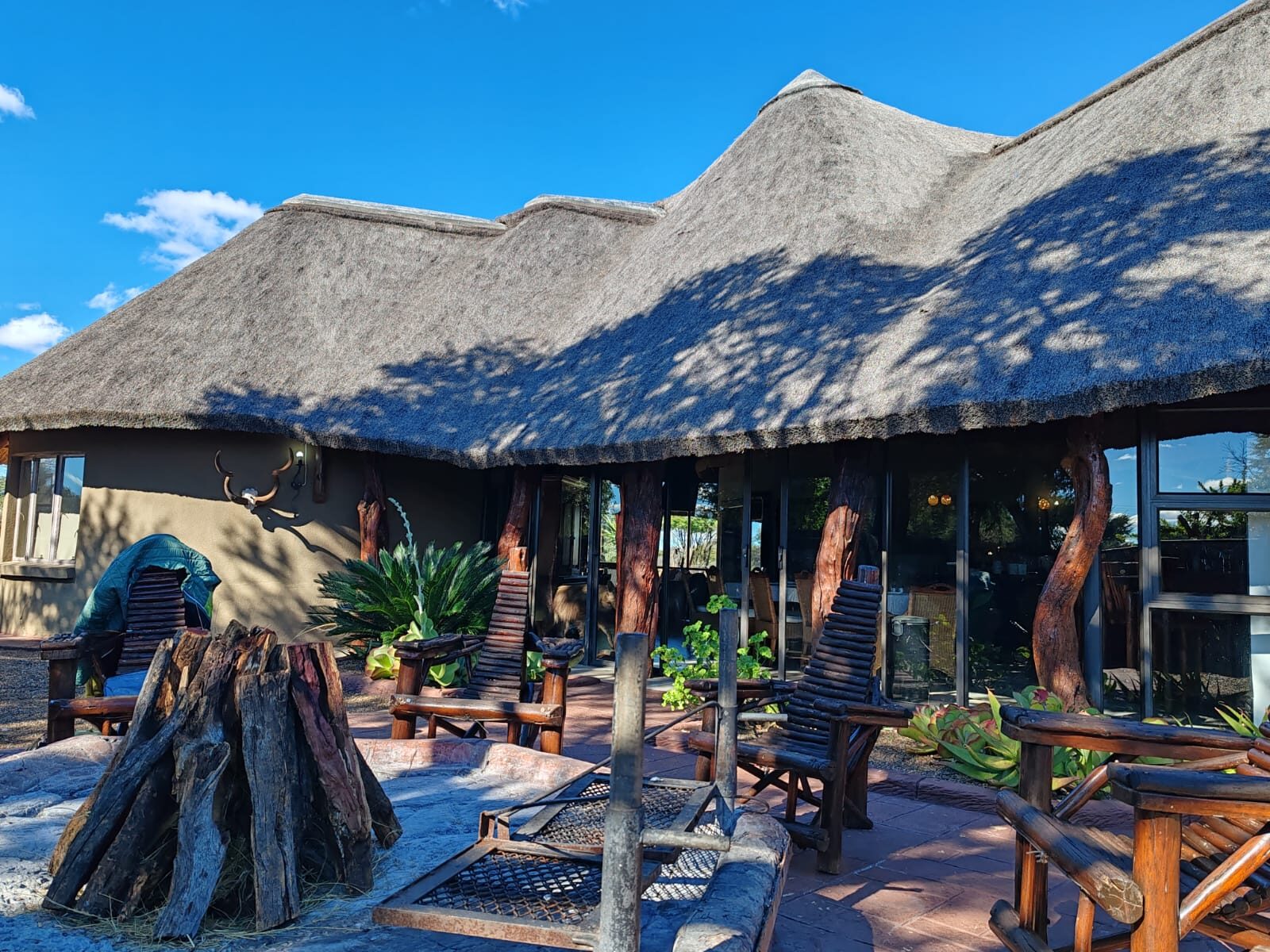 The thatched lodge and its fire pit