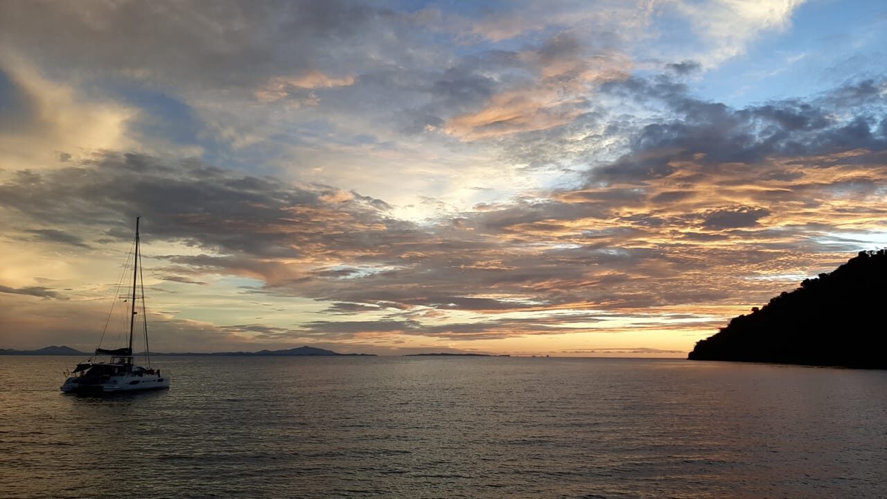 A yacht at anchor off Nosy Be at dusk