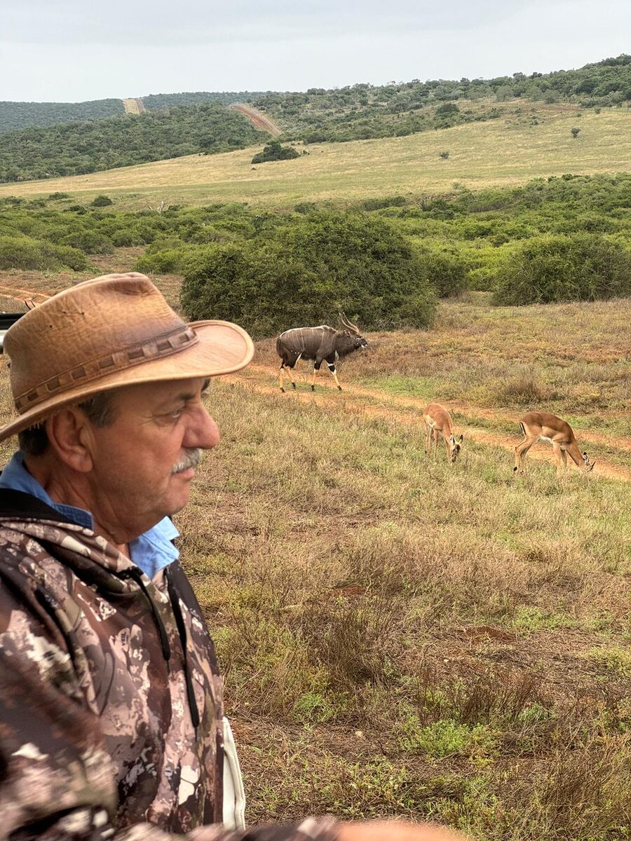 Anthony on a game drive with nyala and impala behind