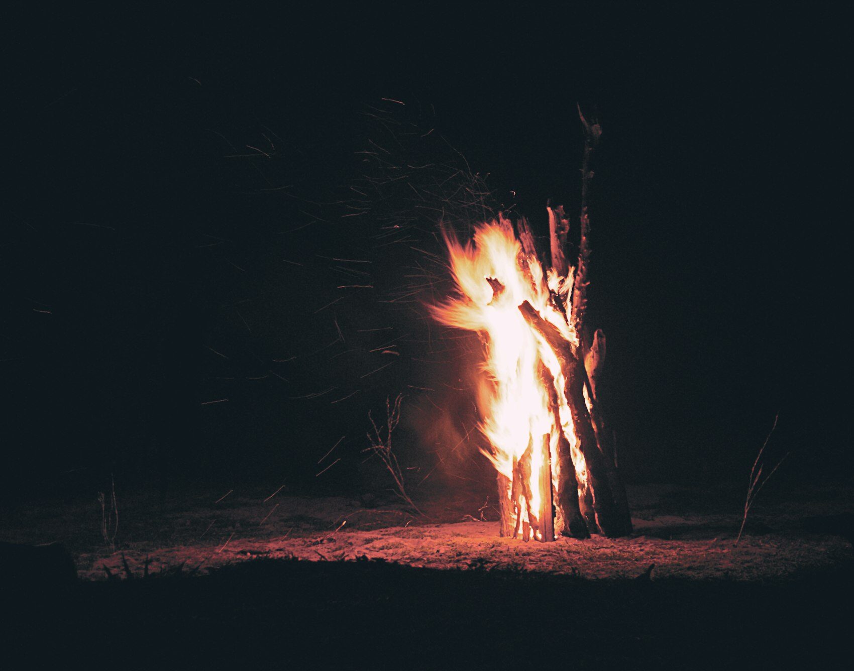 A campfire burning in the dark at a bush camp