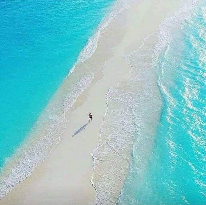 Aerial view of a long white sandbar in turquoise water near Nosy Be