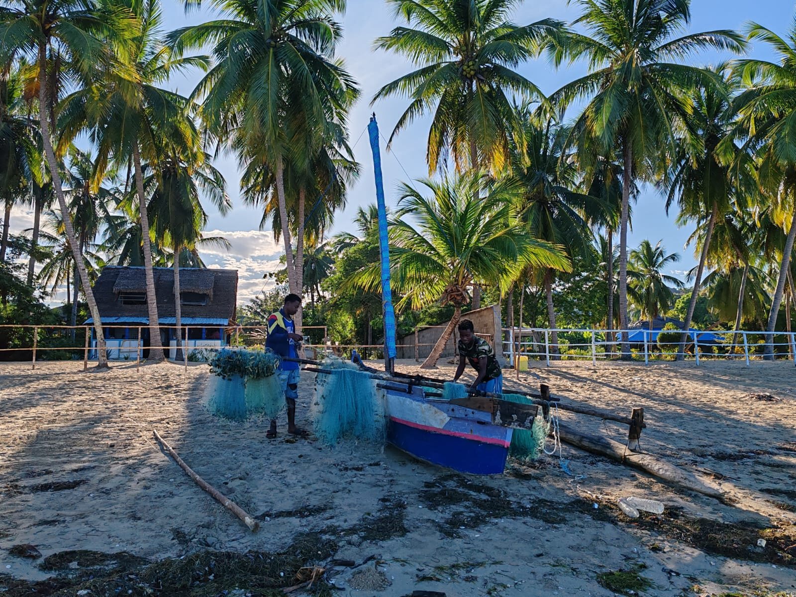 Local fishermen with their pirogue and nets on a village beach on Nosy Be