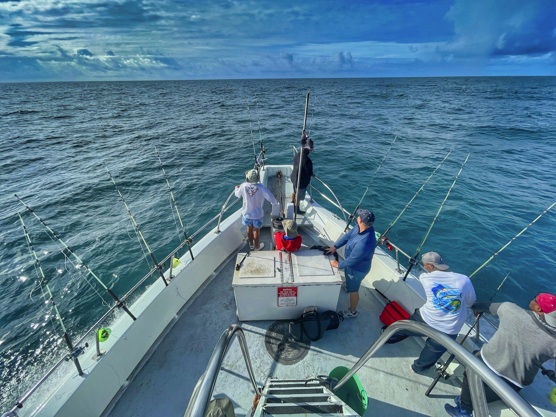 Anglers fishing from the back of a boat at sea