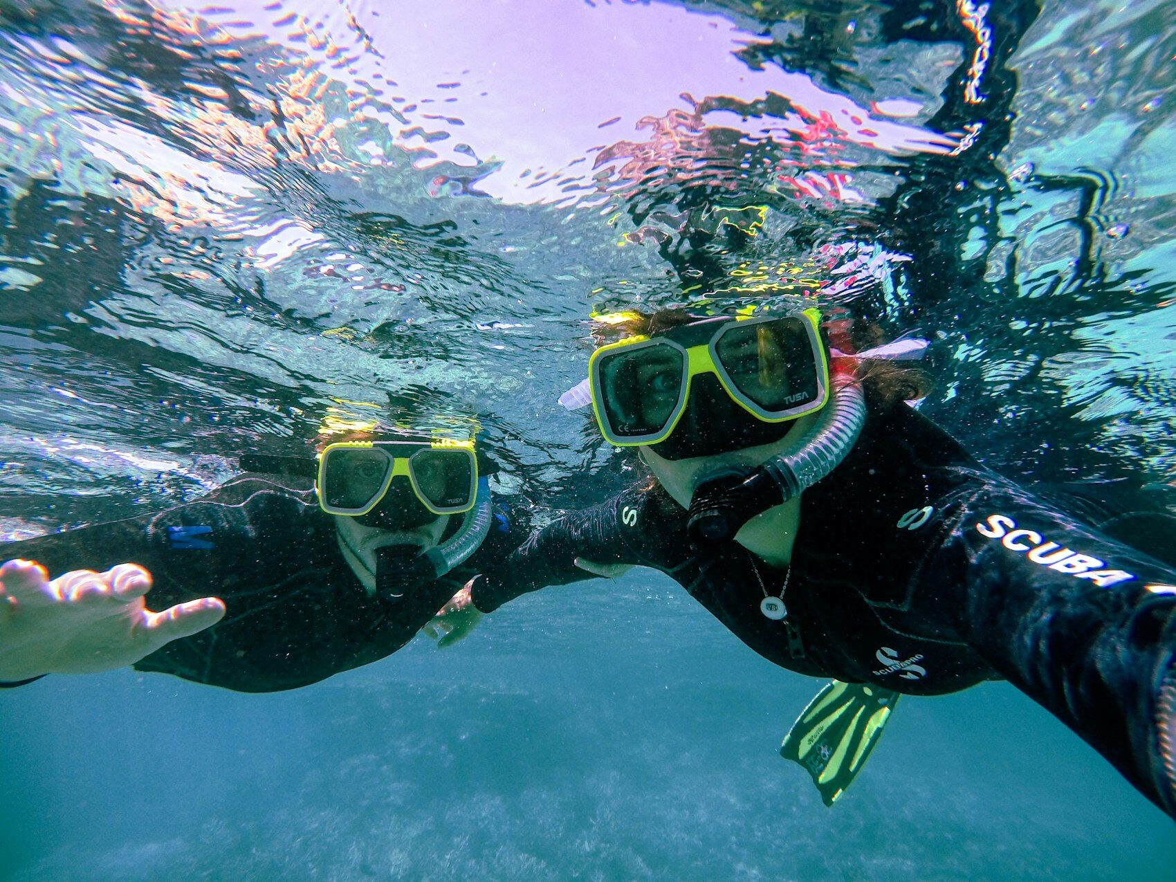 Snorkellers above a shallow coral reef in clear water