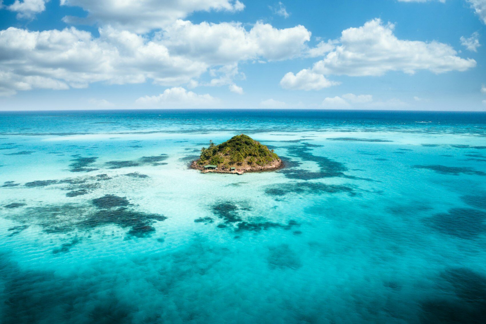 A small palm-covered island in turquoise water