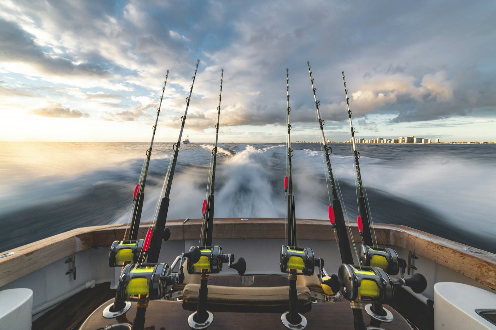 Rods rigged in holders over a boat wake