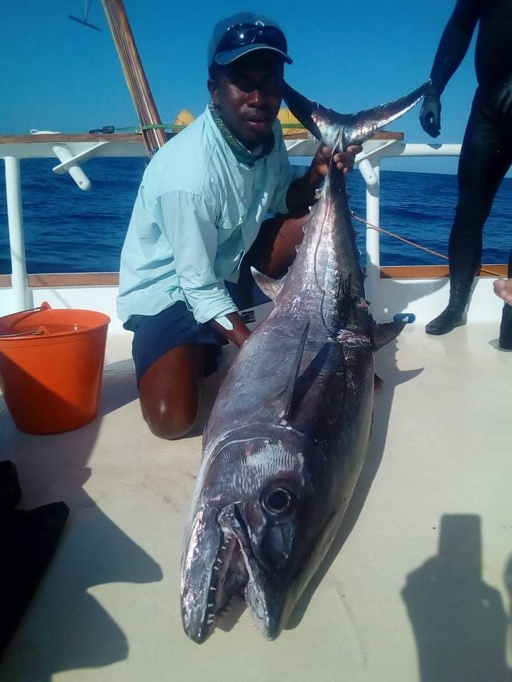 An angler lifting a large tuna on deck